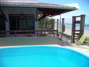 a swimming pool in front of a house with the beach at Pousada Na Beira do Mar in Baía da Traição