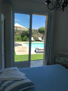 a bedroom with a bed and a view of a pool at Villa "La vie est belle...!" in Cavalaire-sur-Mer +120 photos