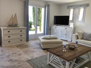 a living room with a tv and a table at Villa "La vie est belle...!" in Cavalaire-sur-Mer