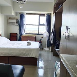 a small bedroom with a bed and a window at eutz condominium daily rental in Cebu City