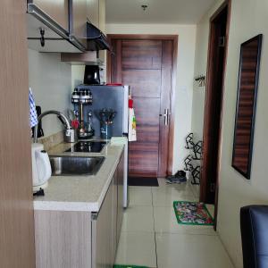 a kitchen with a sink and a refrigerator at eutz condominium daily rental in Cebu City