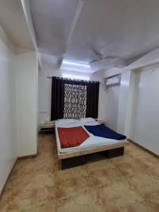 a bedroom with a bed in a room with a window at Sai Anand in Nashik