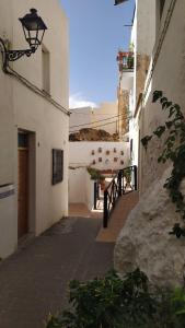 Une allée avec des bâtiments blancs et un éclairage de rue dans l'établissement Casa Castillo, à Torres