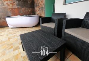 een ligbad naast 2 stoelen en een tafel bij TH Flats com Banheira de Hidromassagem in Governador Valadares