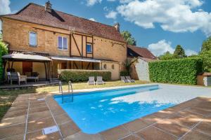 an image of a swimming pool in front of a house at Le Clos Vallis in Sarlat-la-Canéda