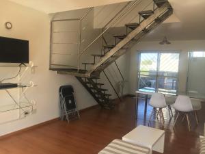 a living room with a staircase and a table and chairs at Rio Negro Loft in Viedma