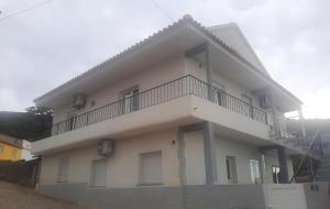 a white building with a balcony on top of it at Eira do Cajado 