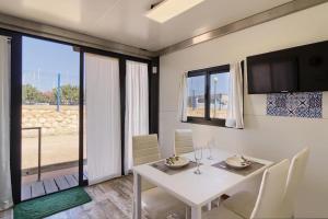 comedor con mesa blanca y sillas en Houseboat Sardinia Suite, en Cagliari