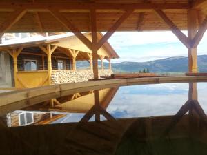 AradaCabana Trif的游泳池中房屋的倒影