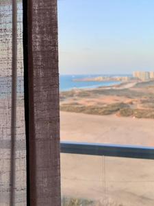 een raam met uitzicht op het strand en de oceaan bij דירת סטודיו על הים בצפון תל אביב in Tel Aviv