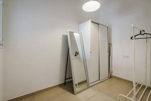 La salle de bains est pourvue d'un miroir et d'un mur blanc. dans l'établissement Flea Market 1BR - 6 09 Tankhum St Tel Aviv #, à Tel Aviv