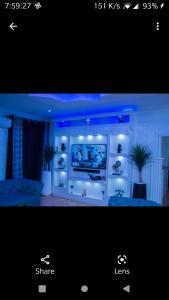 a living room with a tv on a wall at 3 Bedrooms house for Short let Holiday Apartments in Ibadan