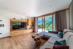 a living room with a couch and a tv at Pension Sonnegg in Saltusio