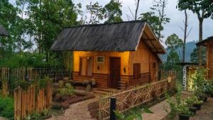 a small house in the middle of a garden at Kampung Bareto Cottage And Resto in Tjisurupan