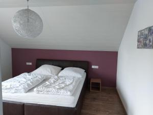 una camera con un letto con una parete viola di FeWo Stauber ad Amtzell