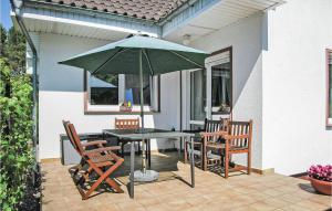 a patio with a table and chairs and an umbrella at Stunning Home In Santoczno With 3 Bedrooms And Wifi in Santoczno