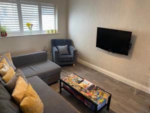 HenreeenOnWidewater في لانسينغ: غرفة معيشة مع أريكة وتلفزيون بشاشة مسطحة