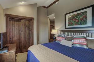 a bedroom with a large bed with a blue blanket at Crystal Peak Lodge 4 Bedroom Ski In, Ski Out Slopeside Condo At The Base Of Peak 7 in Breckenridge +21 photos