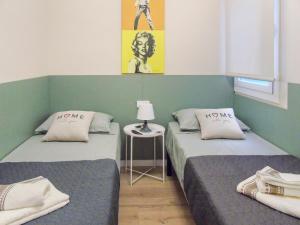 布拉內斯的住宿－CozyCatalonia - Comfortable Apartment in Central Blanes，客房设有两张床和一张带台灯的桌子。
