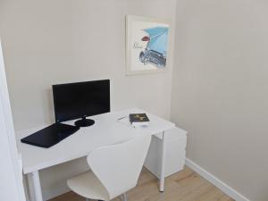a white desk with a computer on top of it at CozyCatalonia - Comfortable Apartment in Central Blanes in Blanes