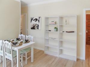CozyCatalonia - Comfortable Apartment in Central Blanes في بلانيس: غرفة طعام مع طاولة ورفوف بيضاء