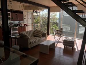 sala de estar con sofá y silla en Rio Negro Loft en Viedma