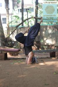 a baby with a bag on its back doing a handstand at NamahStay Hostel, Cowork & Artist residency Arambol in Arambol
