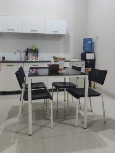 - une cuisine avec une table et des chaises blanches dans l'établissement Choko Homestay, à Colomadu