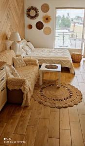 - une chambre avec un lit et une table sur du parquet dans l'établissement Boho apartament - studio, à Kołobrzeg
