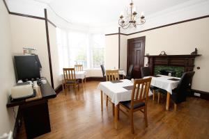 a dining room with tables and chairs and a fireplace at Kinnoch Lodge in Dalneigh