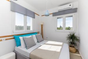 a bedroom with a bed and two windows at Newly Built All Season Resort in Néa Sílata