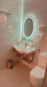 y baño con lavabo, espejo y aseo. en Taj Al Eiman Hotel en Medina