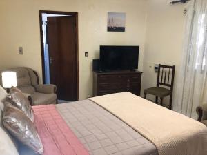 - une chambre avec un lit et une télévision à écran plat dans l'établissement Casa Bica do Cais - By the Sea, à Paul do Mar