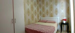 een slaapkamer met een bed met roze lakens en een muur bij Colony Beach Hotel Apartment Tel Aviv Bat Yam 36 in Bat Yam
