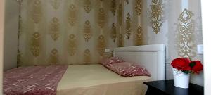 een slaapkamer met een bed en een vaas met rozen bij Colony Beach Hotel Apartment Tel Aviv Bat Yam 36 in Bat Yam