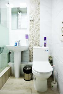 ein Badezimmer mit einem weißen WC und einem Waschbecken in der Unterkunft UB Guesthouse & Tours in Ulaanbaatar