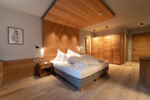 - une chambre avec un lit et un mur en bois dans l'établissement Bad Ratzes, à Alpe di Siusi