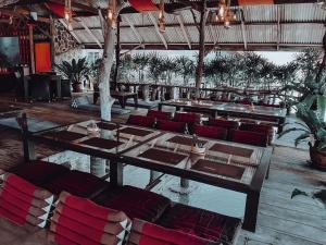 a restaurant with a long table and red chairs at JERPORDEE Residence in Ko Chang