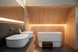 a bathroom with two sinks and two toilets at Miramonti Boutique Hotel in Avelengo +37 photos