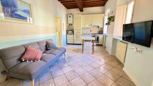 ein Wohnzimmer mit einem Sofa und einer Küche in der Unterkunft Livorno tra mare e città in Livorno