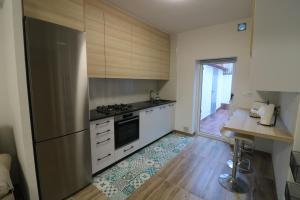 uma cozinha com electrodomésticos em aço inoxidável e piso em madeira em Casa adosada con pequeño patio em Campanario