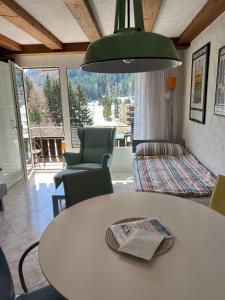 een kamer met een tafel en stoelen en een groot raam bij Golfresidenz Apartment Davos in Davos