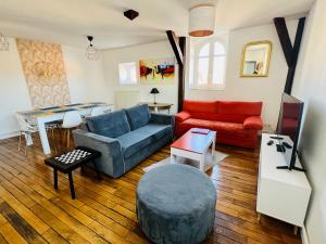 ein Wohnzimmer mit einem Sofa und einem Tisch in der Unterkunft Appartement coeur centre-ville cosy et chaleureux rue Carnot in Châlons-en-Champagne