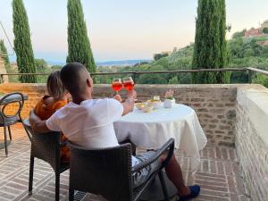 a man and woman sitting at a table drinking wine at Villa del Sole Siena in Siena