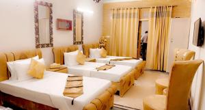 ein Hotelzimmer mit 2 Betten und einem Sofa in der Unterkunft Galaxy Lodge in Islamabad