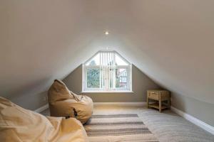 a attic room with a bed and a window at Carrington 3 Bedroom Home, FREE PARKING and Close to the City Centre in Nottingham