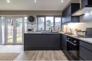 a kitchen with black cabinets and a counter top at 3 bed house Free parking in Nottingham