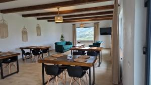 a dining room with tables and chairs and a living room at Complex Dealu' Frumos in Întorsura Buzăului