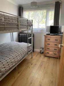 a bedroom with two bunk beds and a television at 265 Belle Aire, Modern Property in Hemsby
