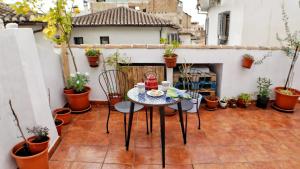 a patio with a table and chairs on a balcony at Entre Dos Aguas in Granada
